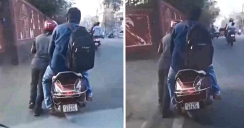 Rapido rider pushing fuel-less scooter while customer sits