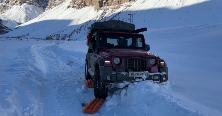बर्फ में गाड़ी चलाते समय रिकवरी कर्षण ट्रैक का इस्तेमाल कर रही Mahindra Thar [वीडियो]